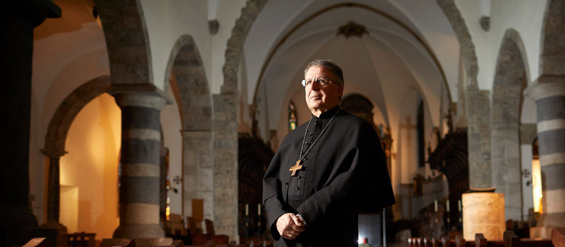 Abt Jean Scarcella steht im Habit in der Abteikirche