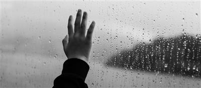 A child's hand on a window pane