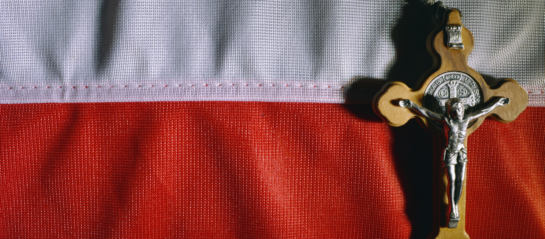 A crucifix lies on a Polish flag