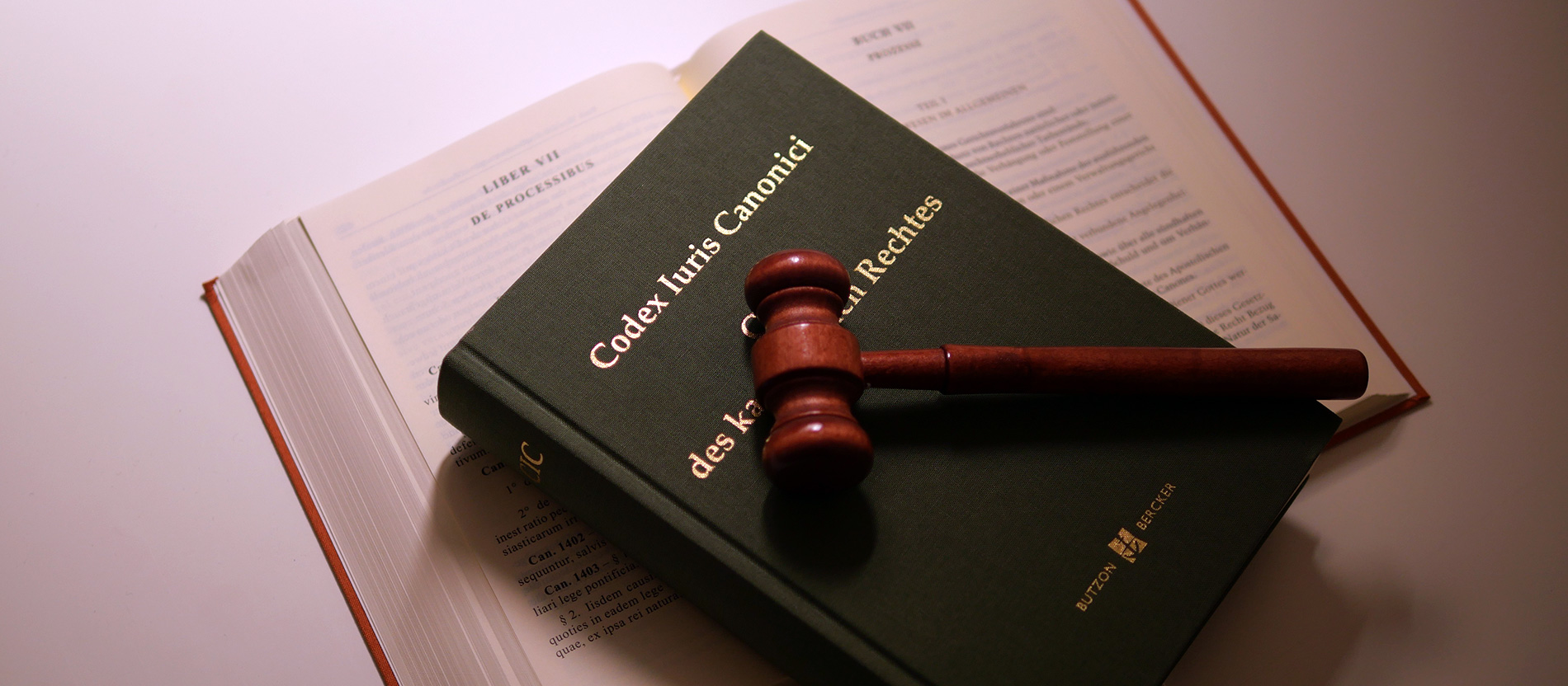 A judge's gavel lies on an edition of the ecclesiastical code CIC