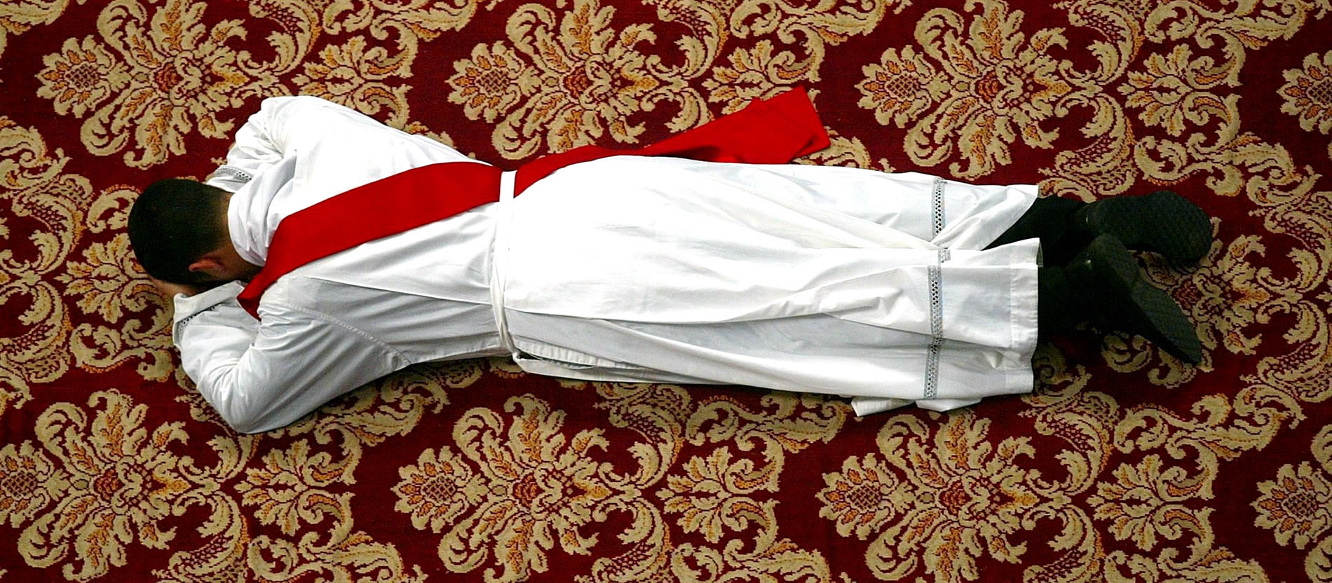 A candidate lies on the floor during his ordination.