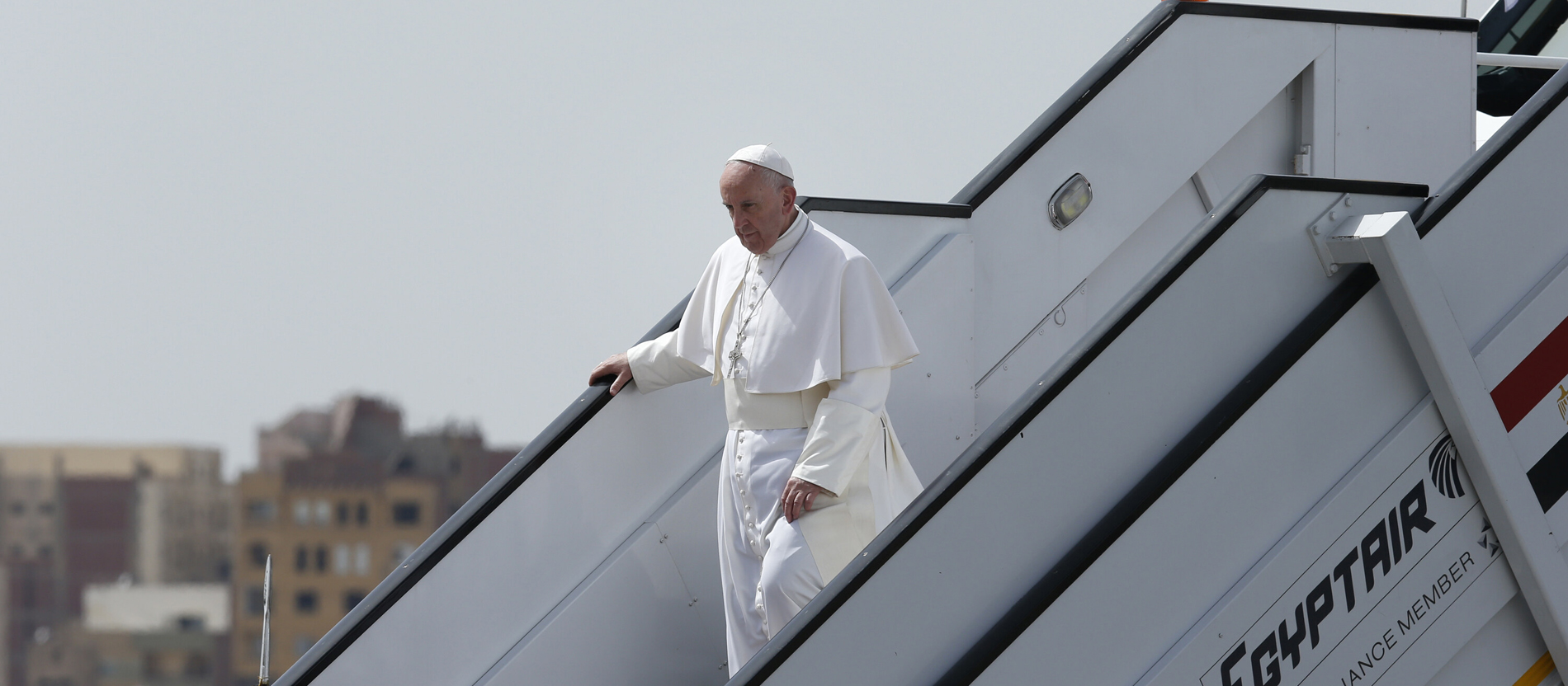Pope Francis descends the boarding bridge of an aeroplane