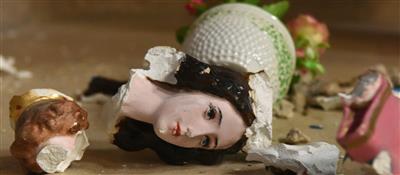 Eine zerbrochene Heiligenfigur liegt auf dem Boden