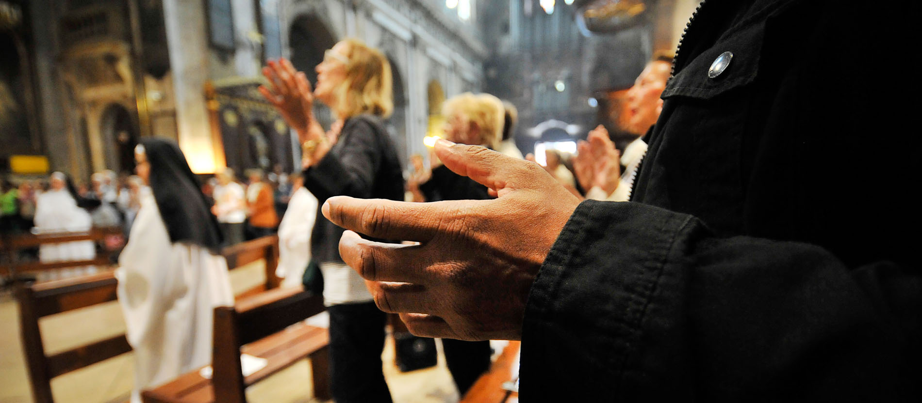 Believers pray the Lord's Prayer at a mass in Paris.