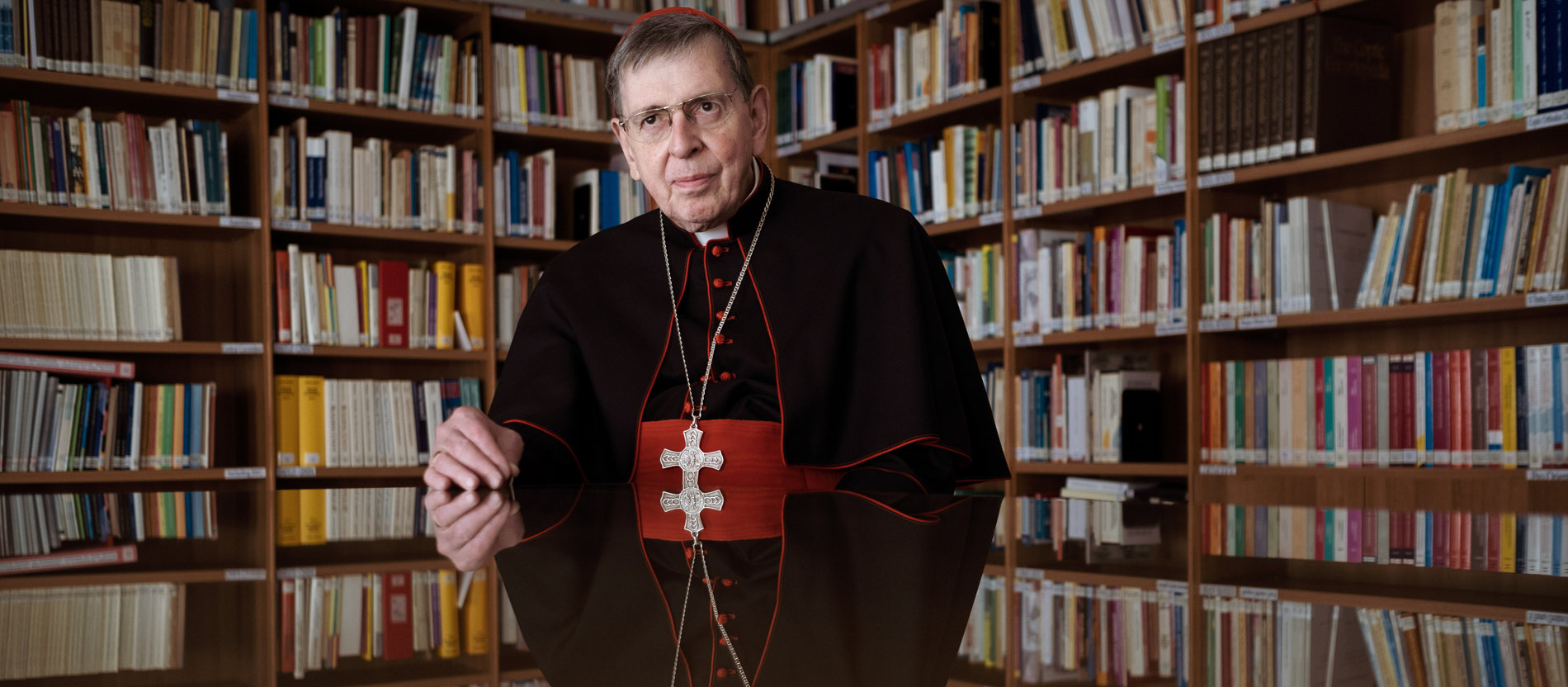 Cardinal Kurt Koch in front of a wall of books