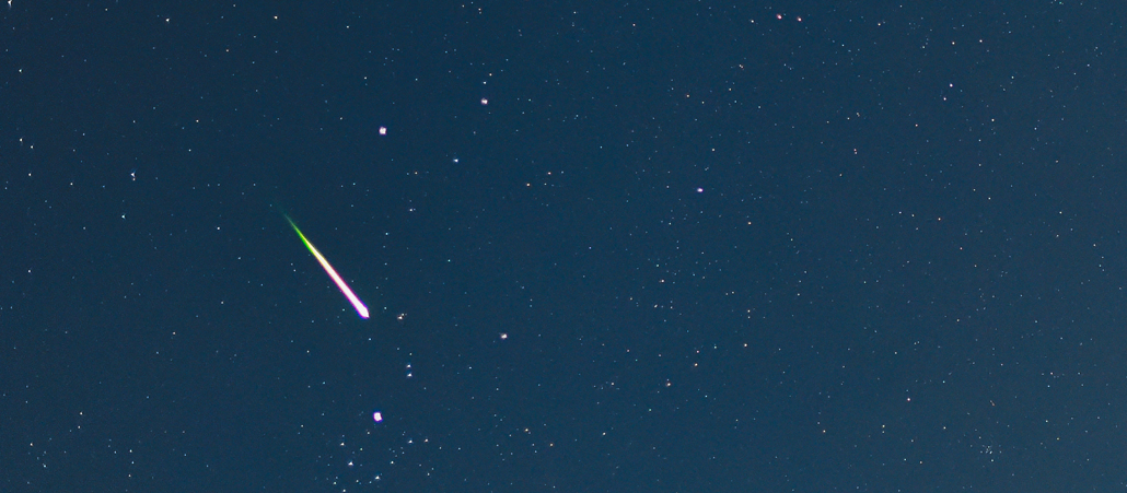 Eine Sternschnuppe ist am Himmel zu sehen.